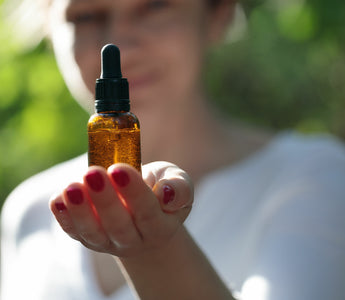 Woman using Vesper Mushrooms liquid extract dropper bottle as part of a daily wellness routine